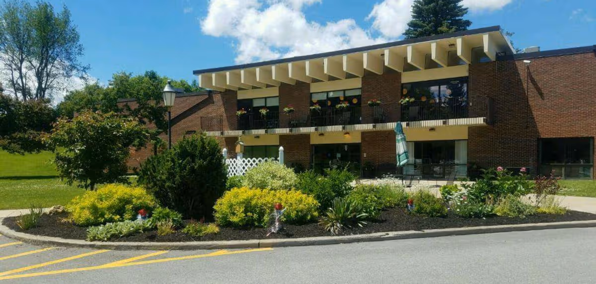 Exterior view of Waterville Residential Care Center with landscaped circular garden and parking.