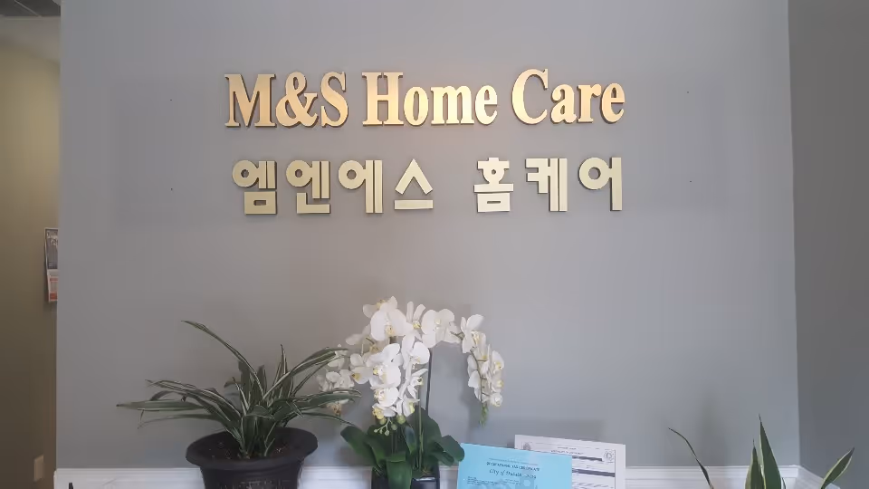 Lobby reception with M&S Home Care sign, Korean text, and potted plants on the counter.