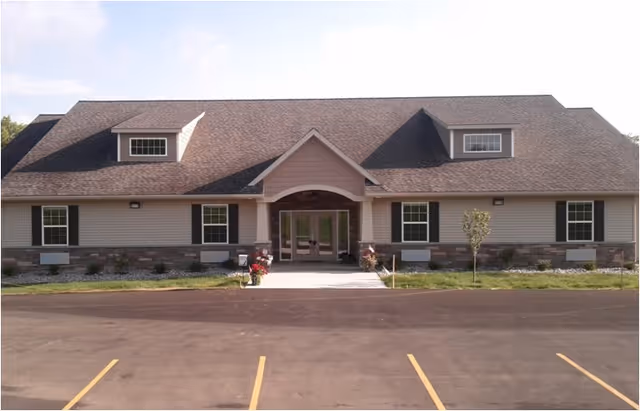 Single-story senior living facility with a welcoming front entrance and parking lot.