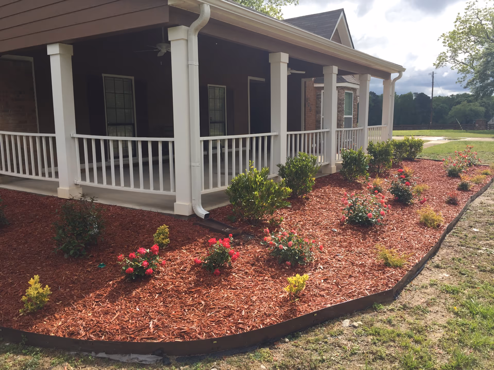 Front view of Estella House with a covered porch and landscaped flower beds along the walkway.
