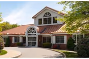 Front exterior view of Alliance Health at Rosewood, a two-story facility with arched windows.