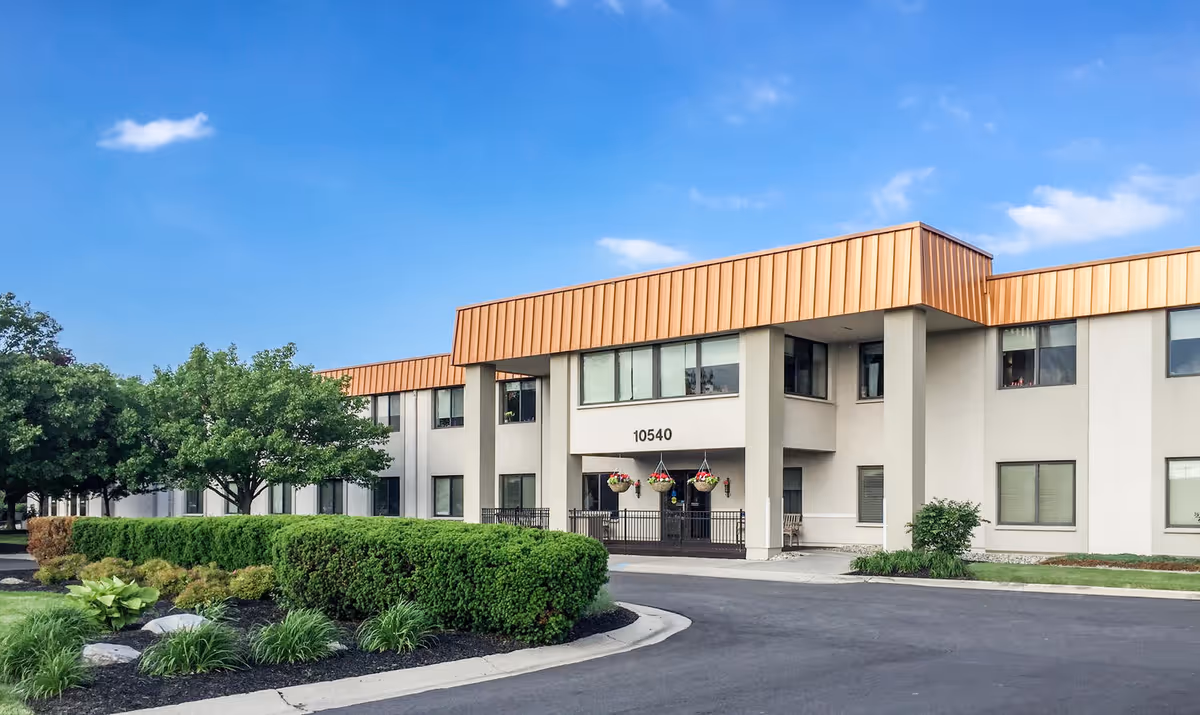 Exterior of Legacy Perrysburg senior living facility with beige walls and orange roof.