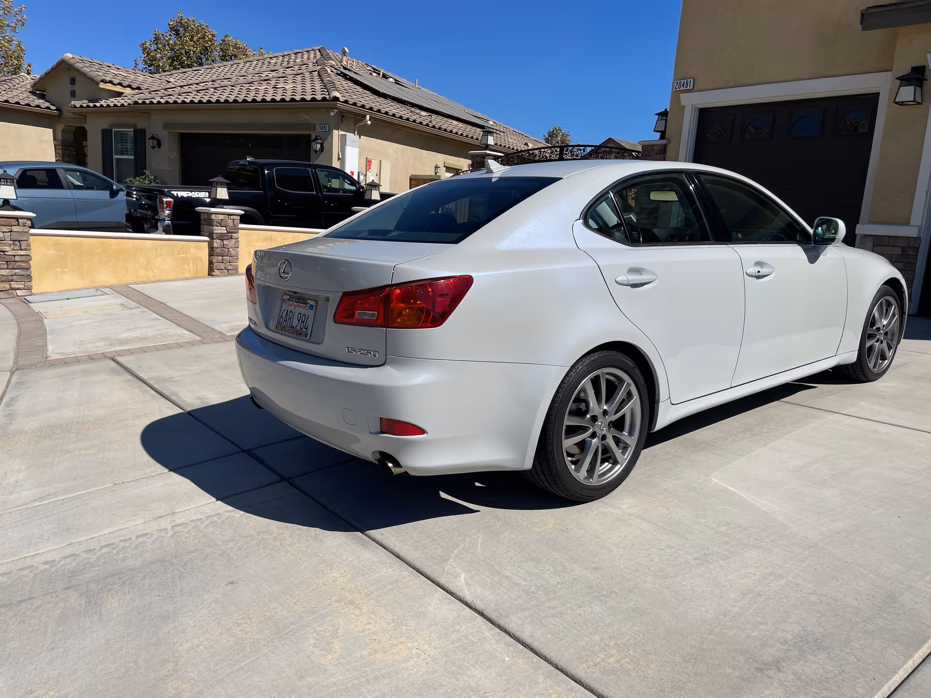 White Lexus sedan parked in a residential driveway in front of Terrace Gardens senior living facility.