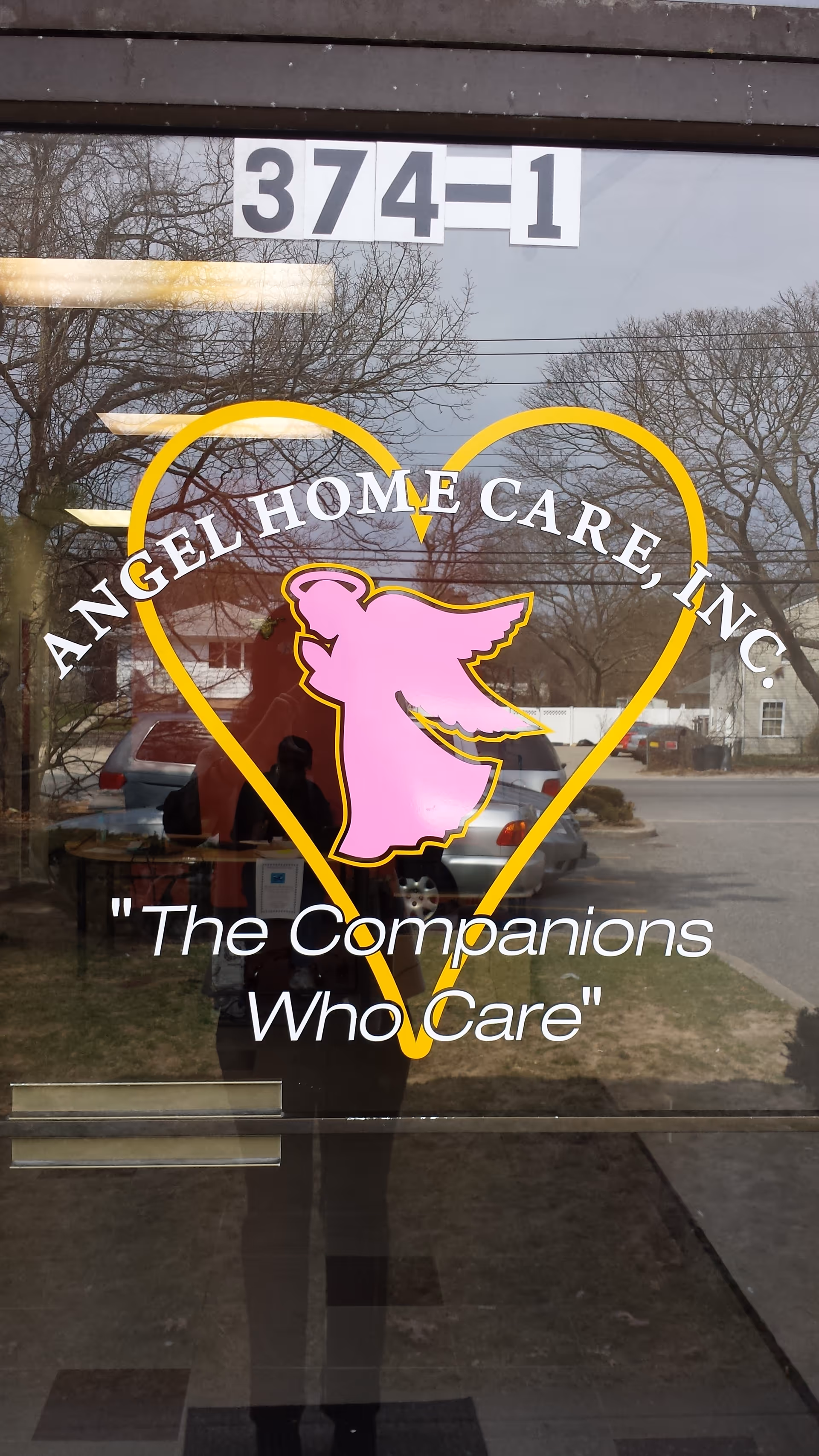 Front entrance door with Angel Home Care logo heart and reflection of the photographer.