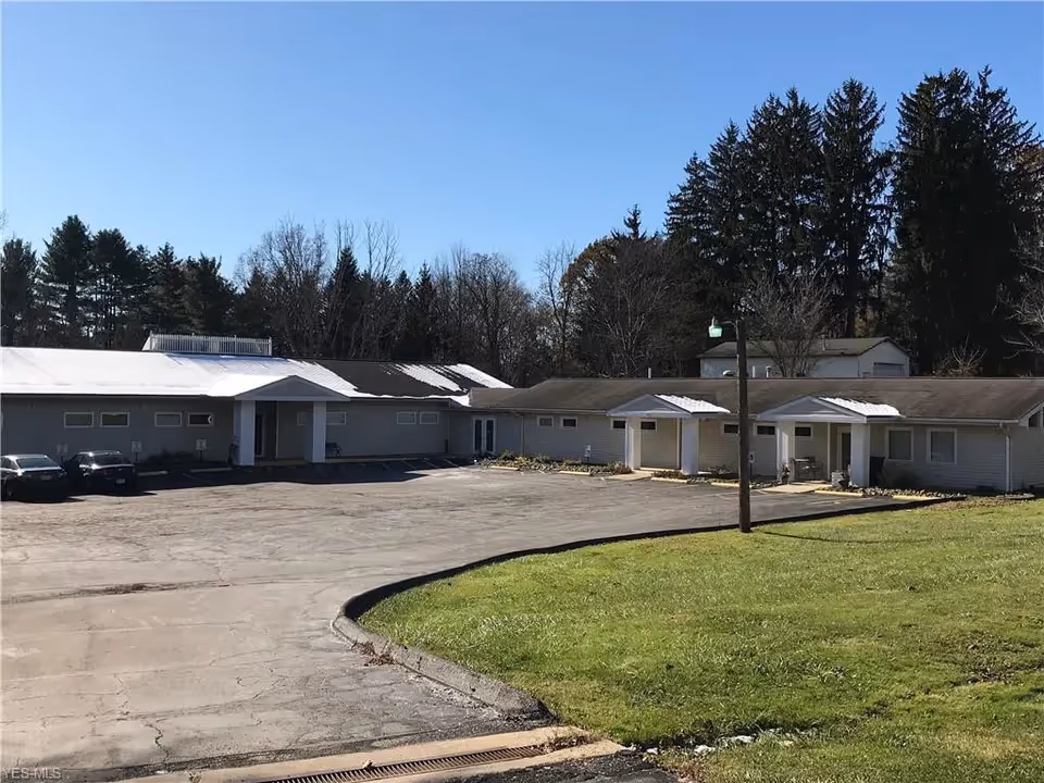Exterior of a single-story senior living facility with a parking lot.
