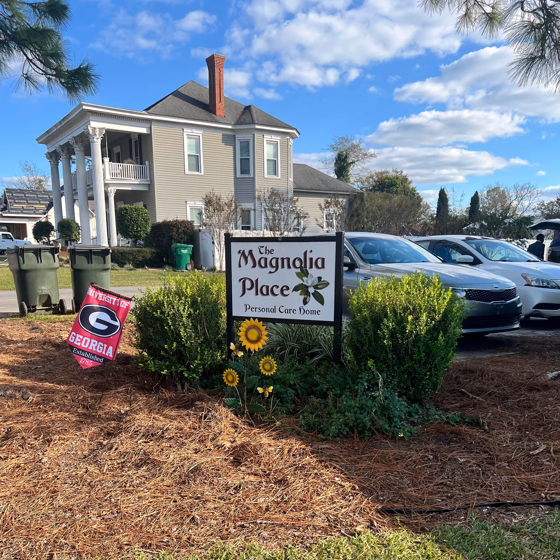 Front view of Magnolia Place Personal Care Home with parked cars and landscaping