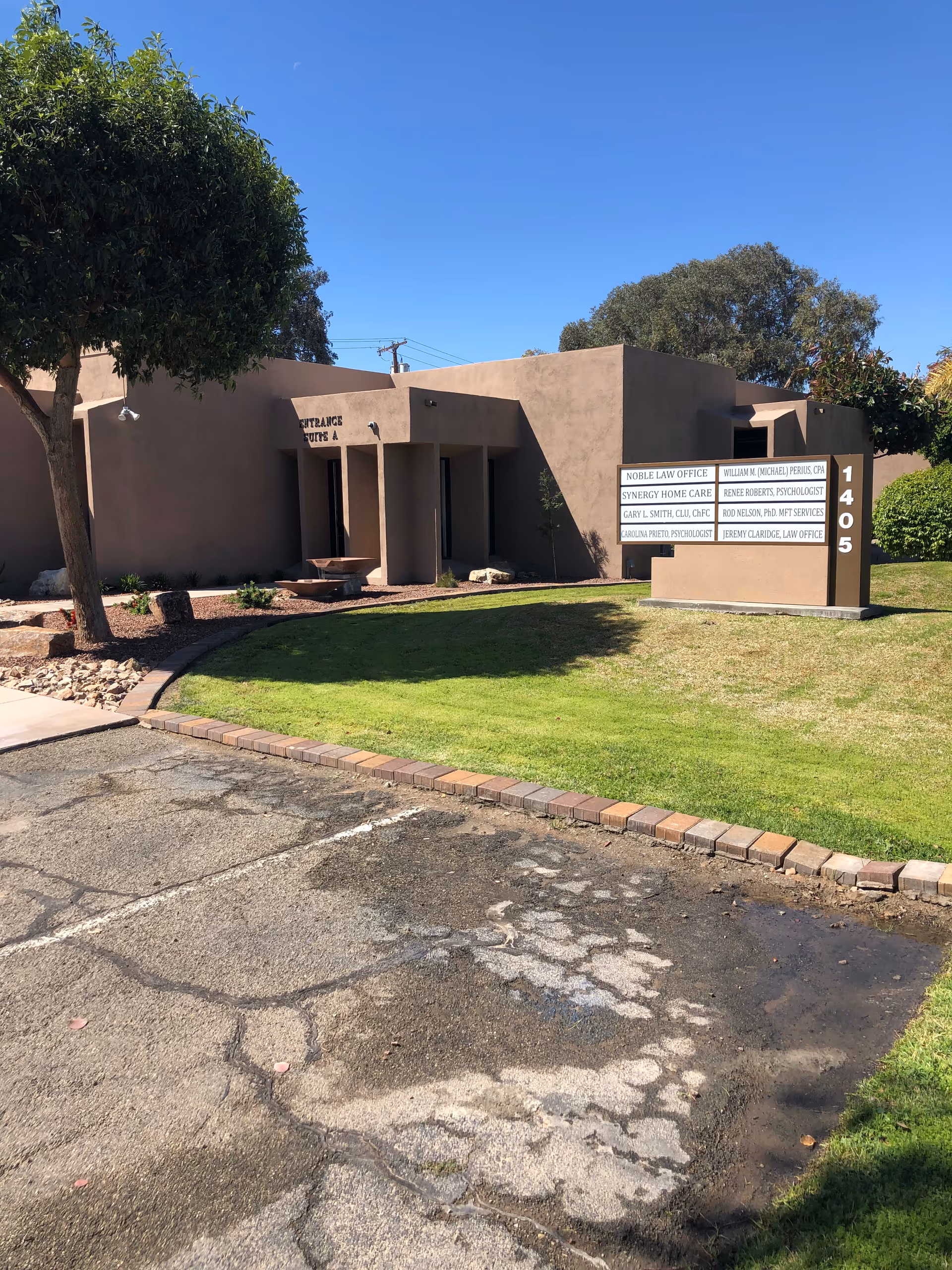 Exterior view of a beige Synergy HomeCare of Yuma building with sign and entrance.