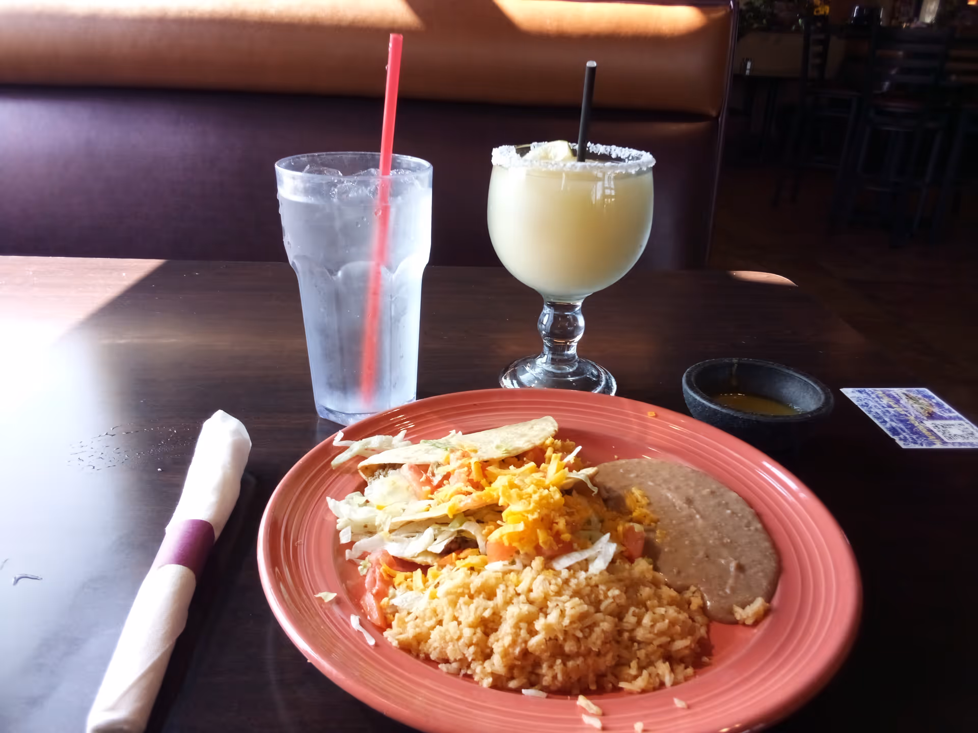 A dining area in a senior living facility with a plate of Mexican-style food and drinks.