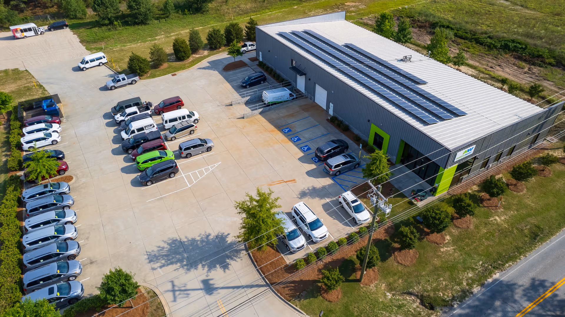 Aerial view of MobilityWorks facility with parking lot and solar panels on the roof.