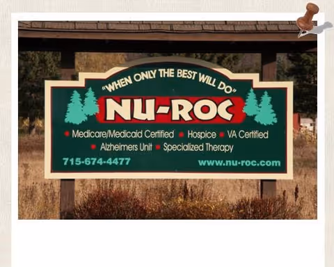 Outdoor Nu-Roc Community Healthcare sign with trees in a grassy area.
