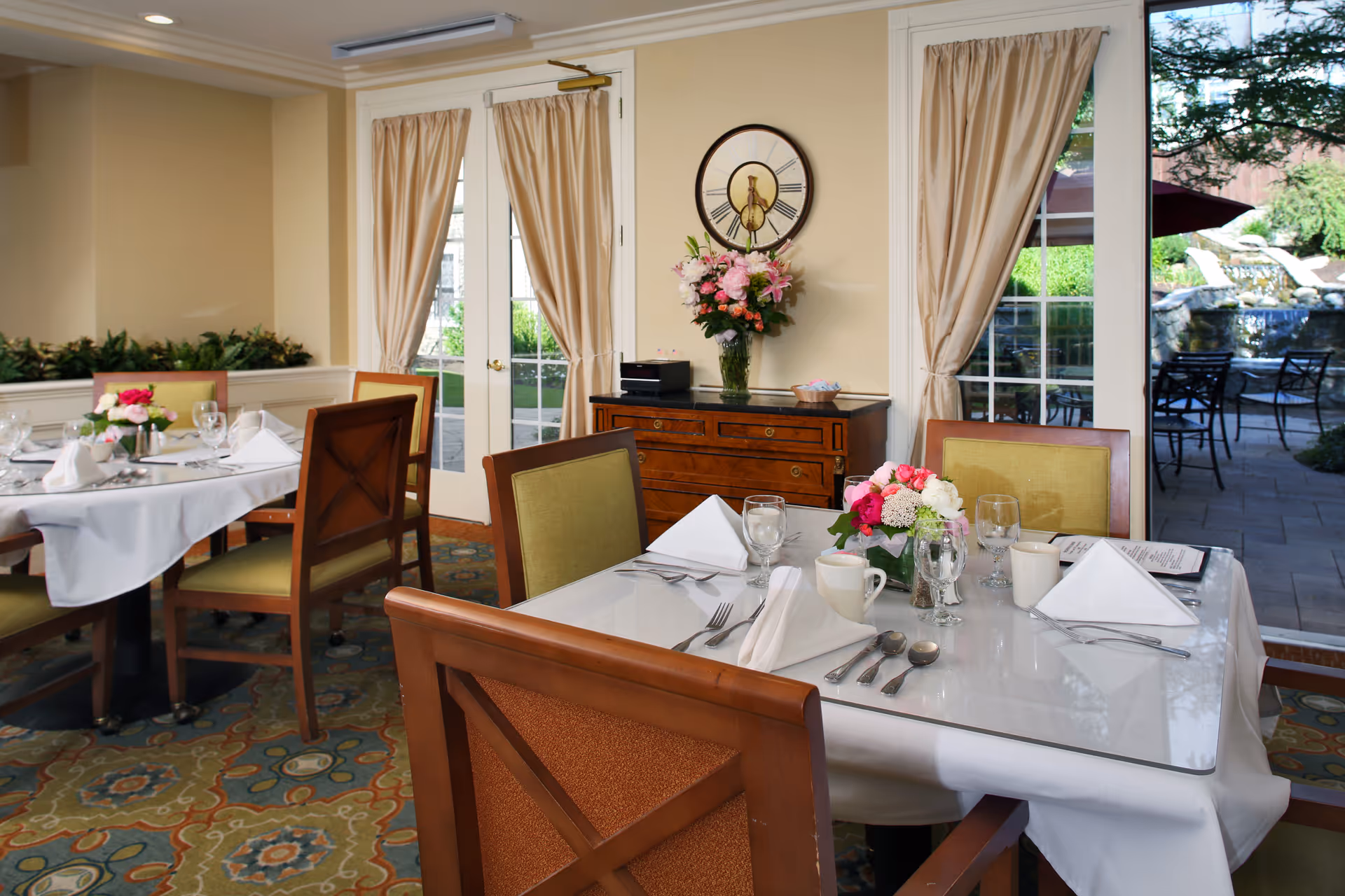 Maplewood at Orange dining room with white-tablecloth tables and patio doors visible outside