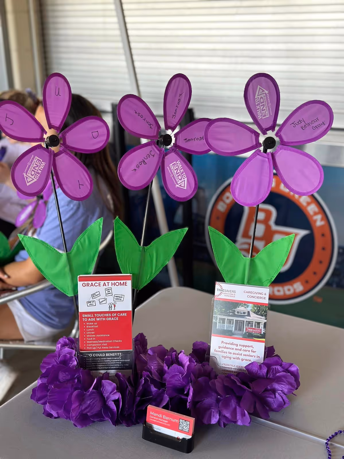 Purple flower decor and promotional materials on a table indoors at Timesavers facility.