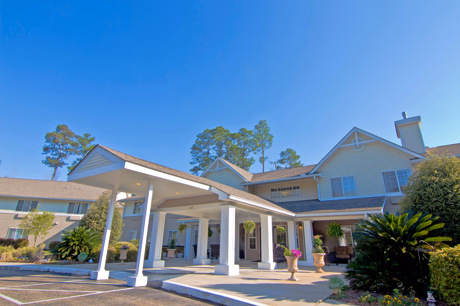 Front exterior of Brookdale Hattiesburg senior living with covered entrance and landscaping.