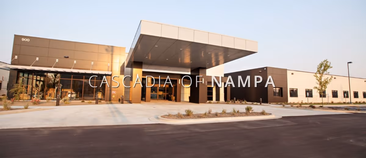 Front entrance of a modern senior living building with a large covered porte-cochère and the name "Cascadia of Nampa" overlaid across the image.