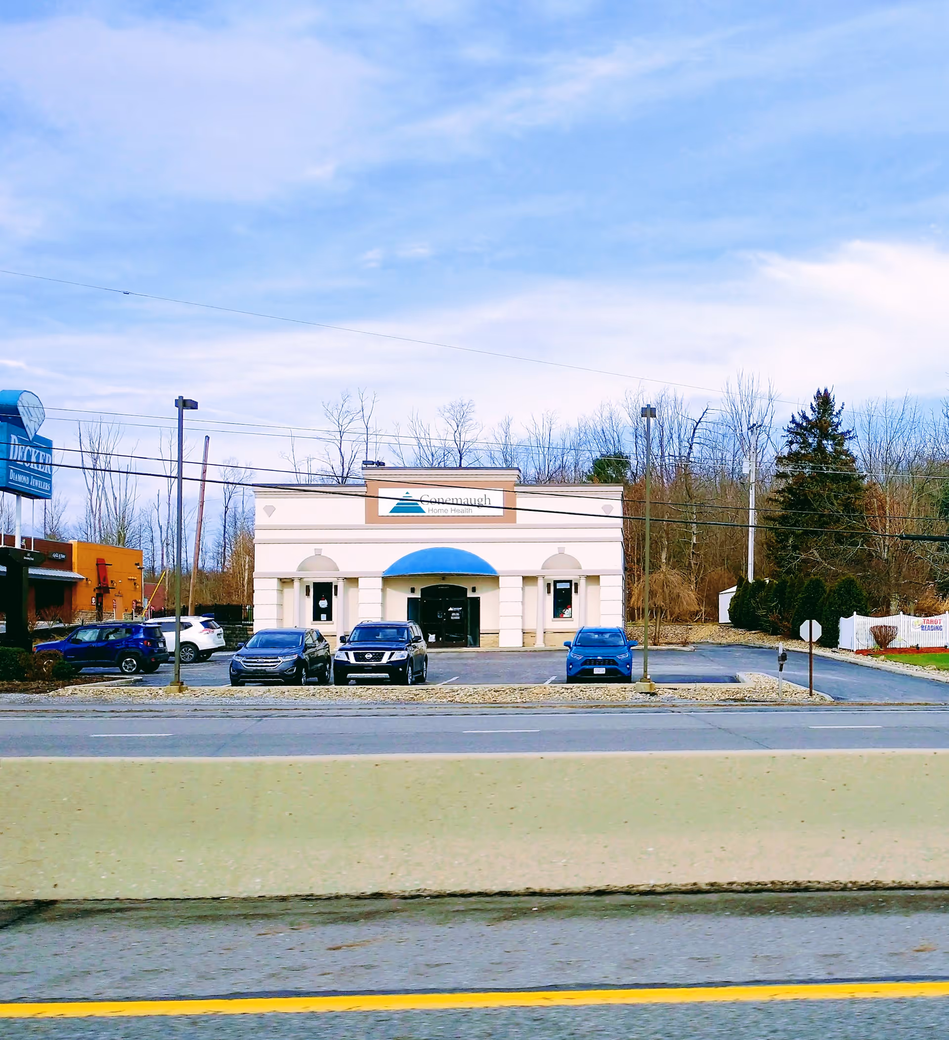 Conemaugh Home Health storefront with blue awning and parked cars.