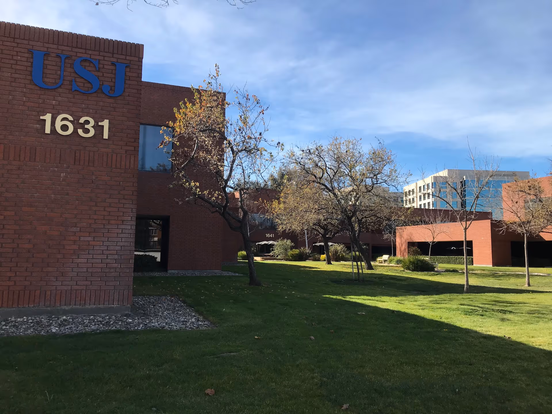 Red brick building with USJ sign and 1631 on a green lawn.