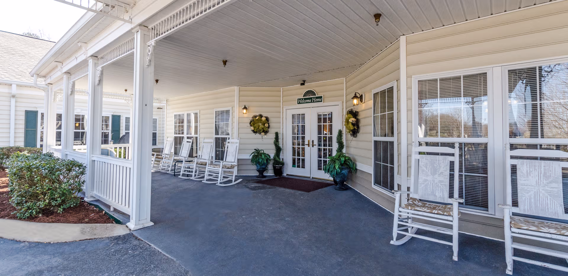Covered front porch of The Bungalows at Bowling Green with white rocking chairs.