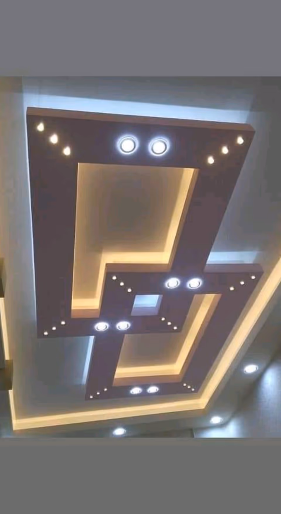Interior ceiling features geometric layered panels with embedded round lights and recessed lighting.