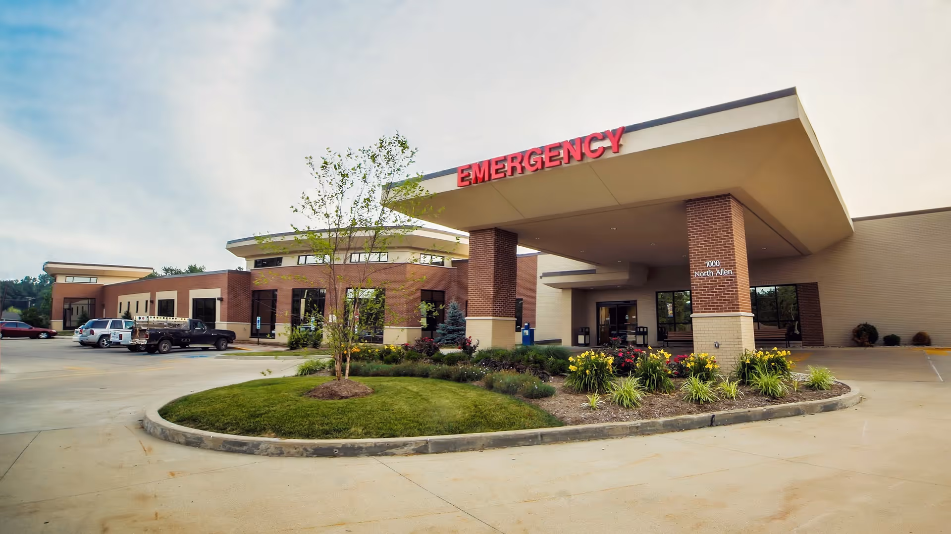 Exterior view of Crawford Memorial Hospital emergency entrance with landscaped roundabout and parked cars