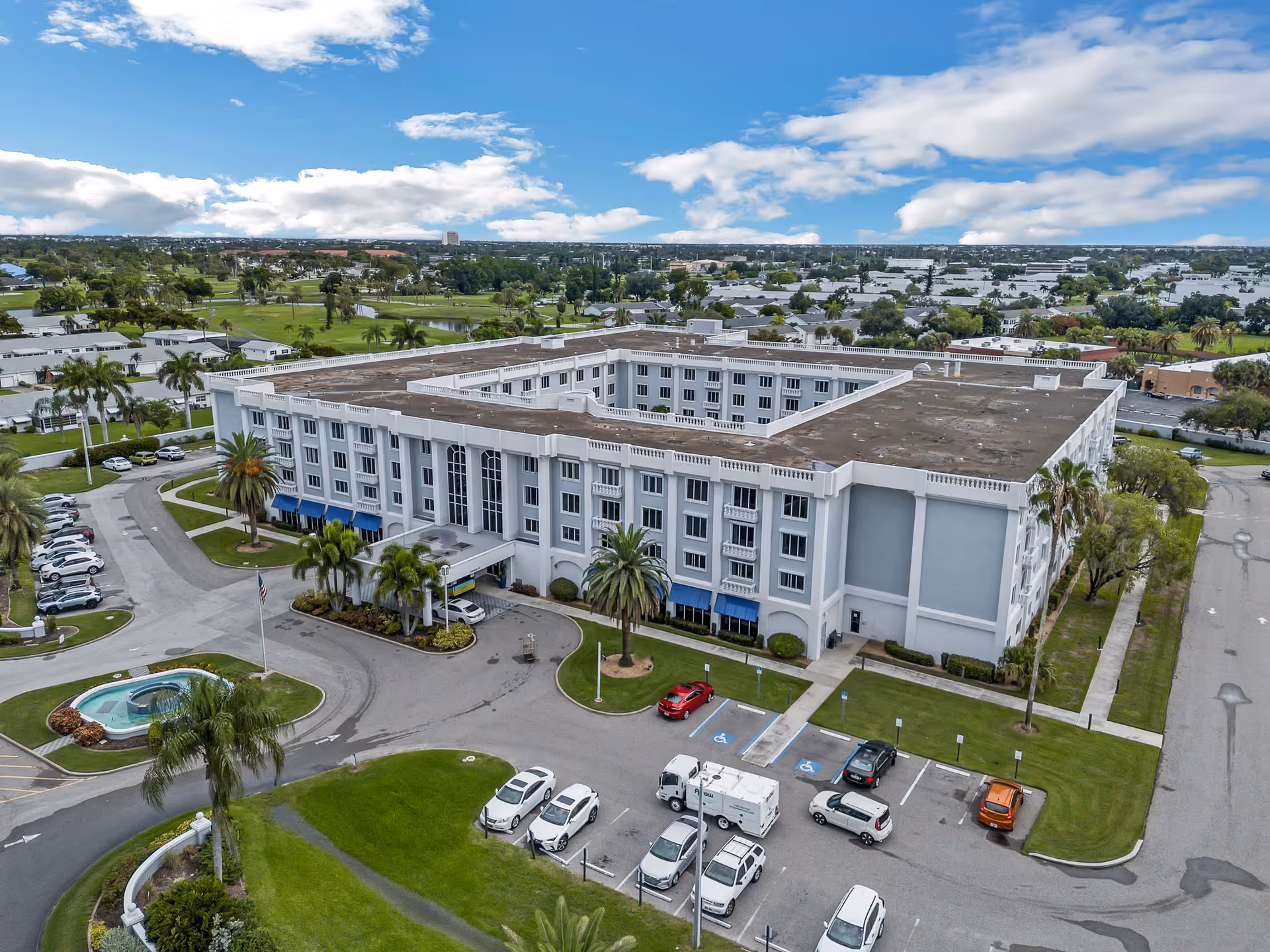 Aerial view of The Summit of Fort Myers exterior building with parking areas and palm trees.