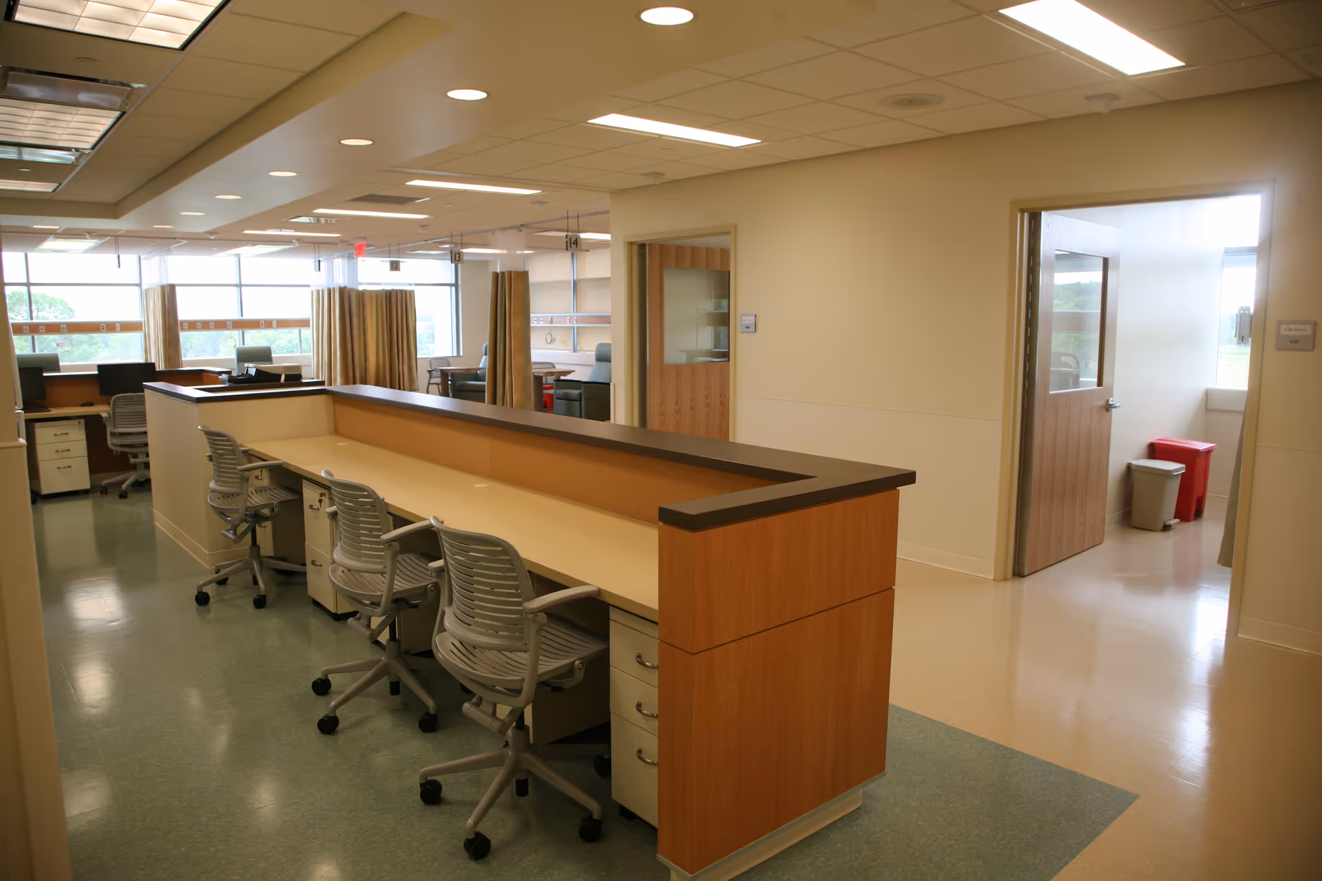 A spacious clinic-like reception area with a long counter and office chairs.
