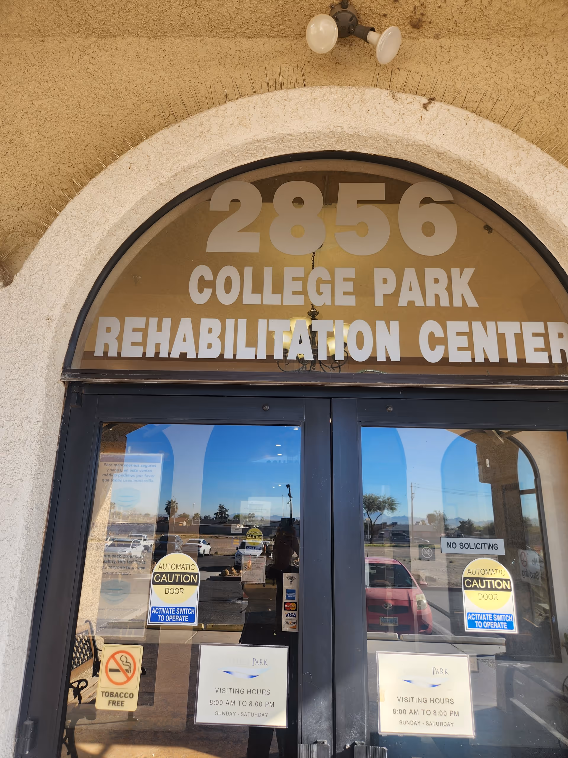 Front entrance of College Park Rehabilitation Center with large arched window sign above double doors.
