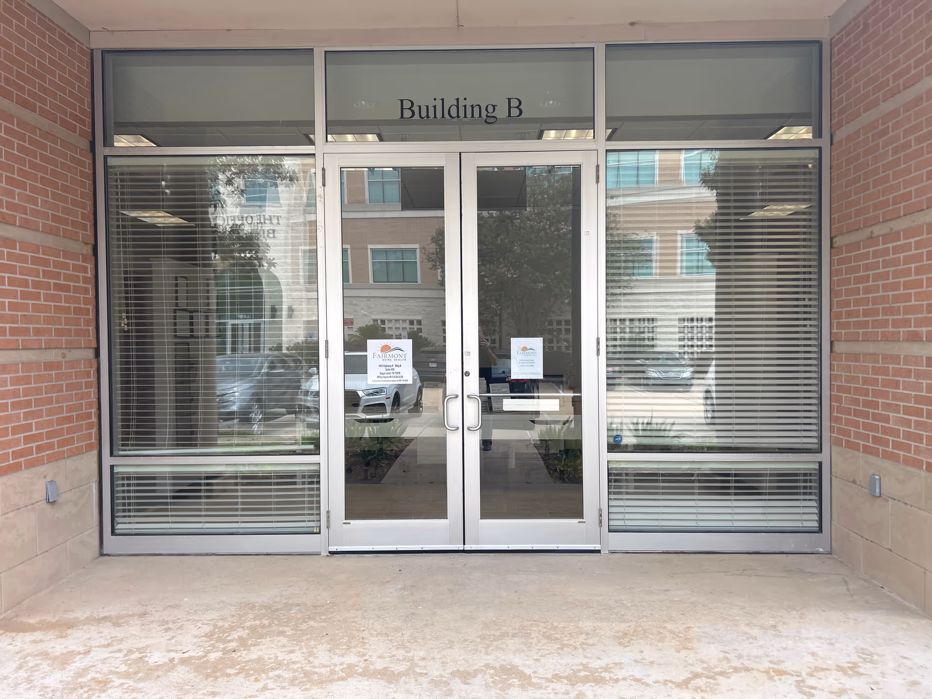 Brick exterior entrance with glass doors labeled Building B.