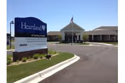 Exterior view of a senior living facility with a curved driveway and front entrance.
