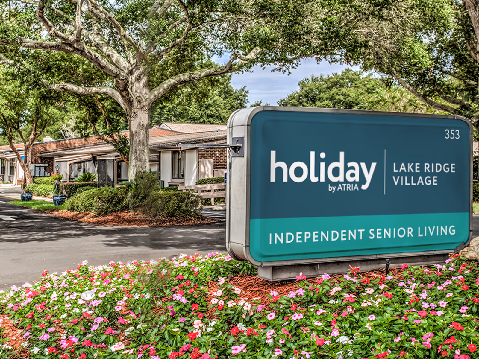 Exterior view of Lake Ridge Village sign with landscaping and a low-rise building behind.