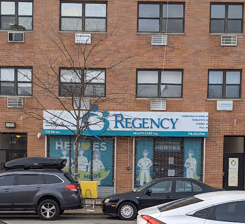 Brick building exterior with Regency Health Care storefront sign and parked cars.