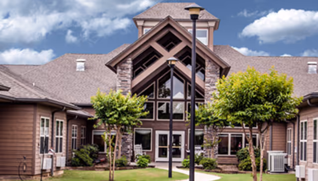 Front view of Lone Star Living facility with trees, lawn, and a wide entrance.