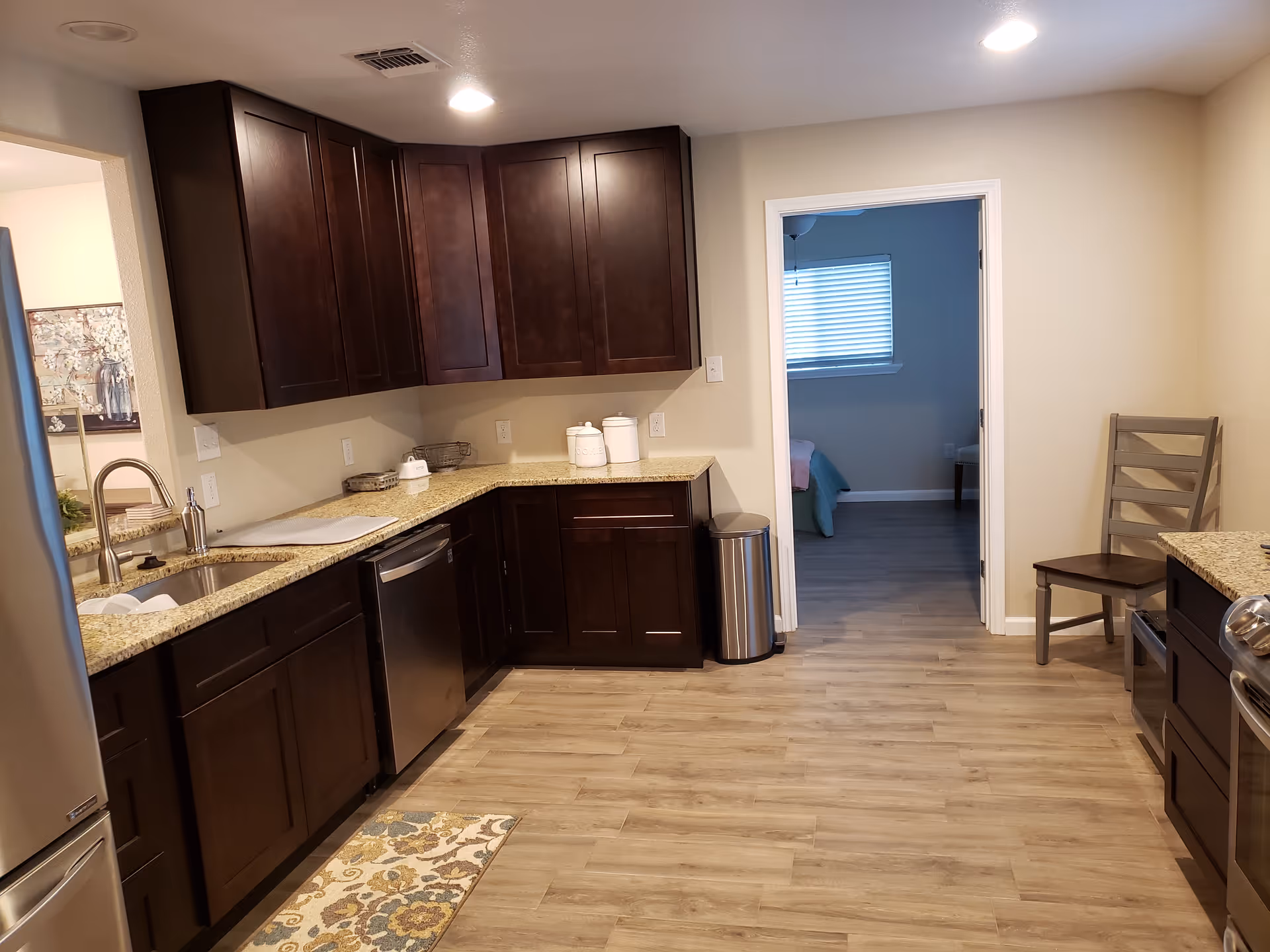 Modern kitchen with dark wood cabinets, granite counters, and stainless appliances.