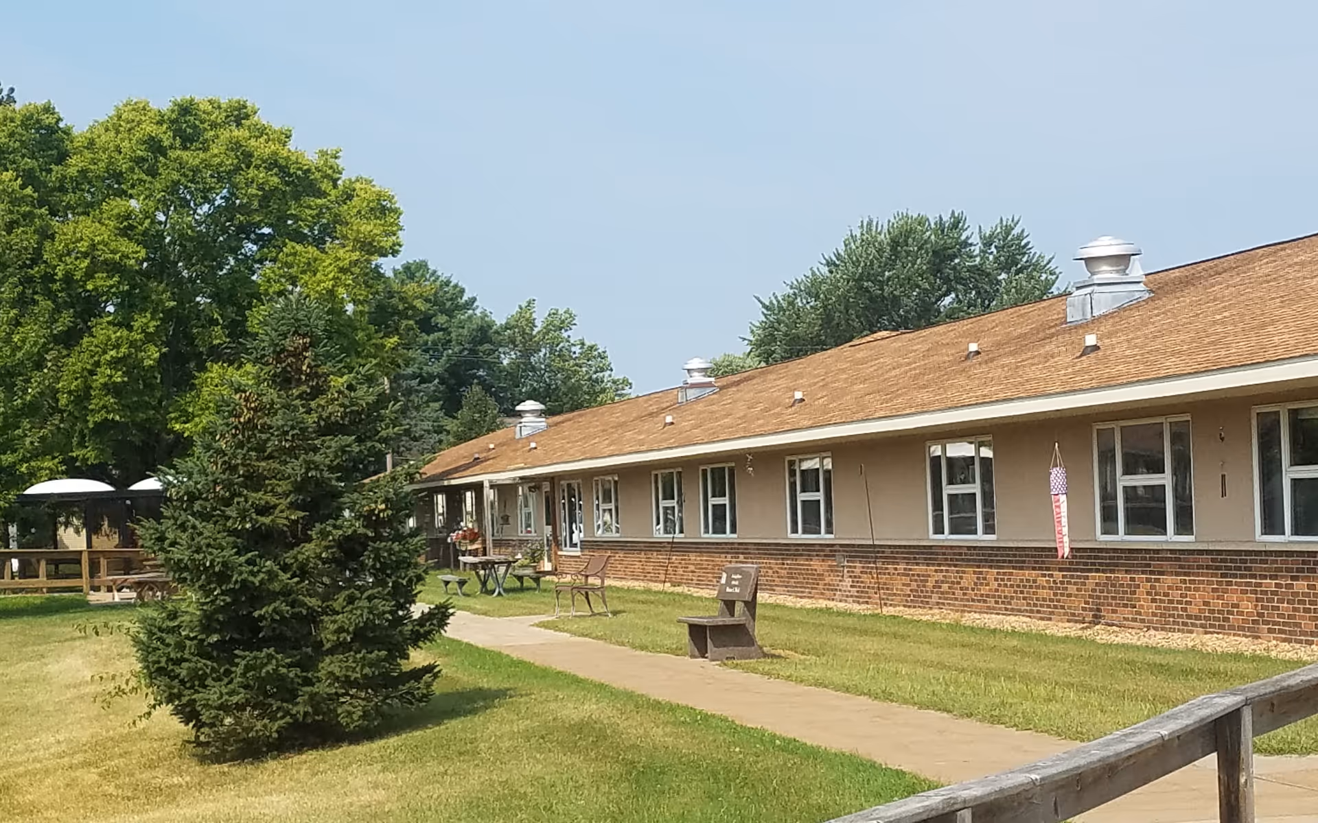 Exterior of Onalaska Care Center with brick base, tan siding, and outdoor seating.