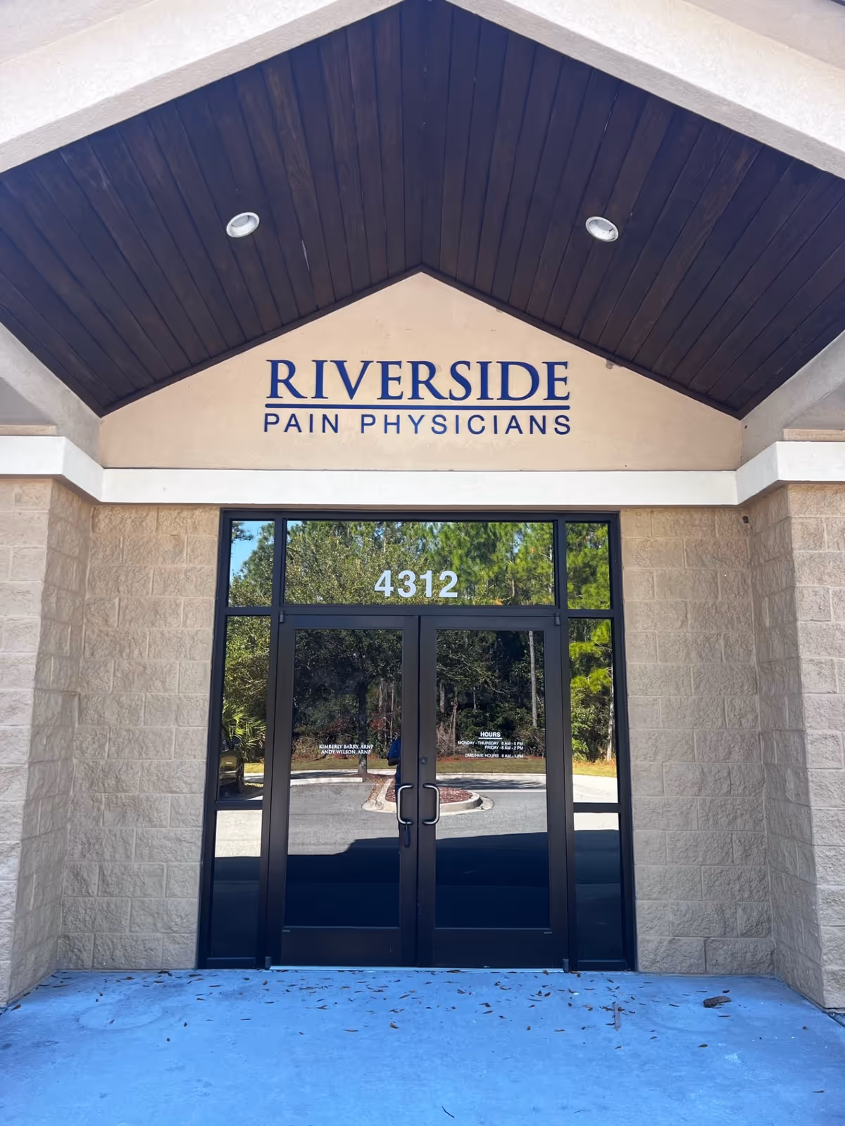 Front entrance of Riverside Pain Physicians, glass doors, address 4312, beige stone facade