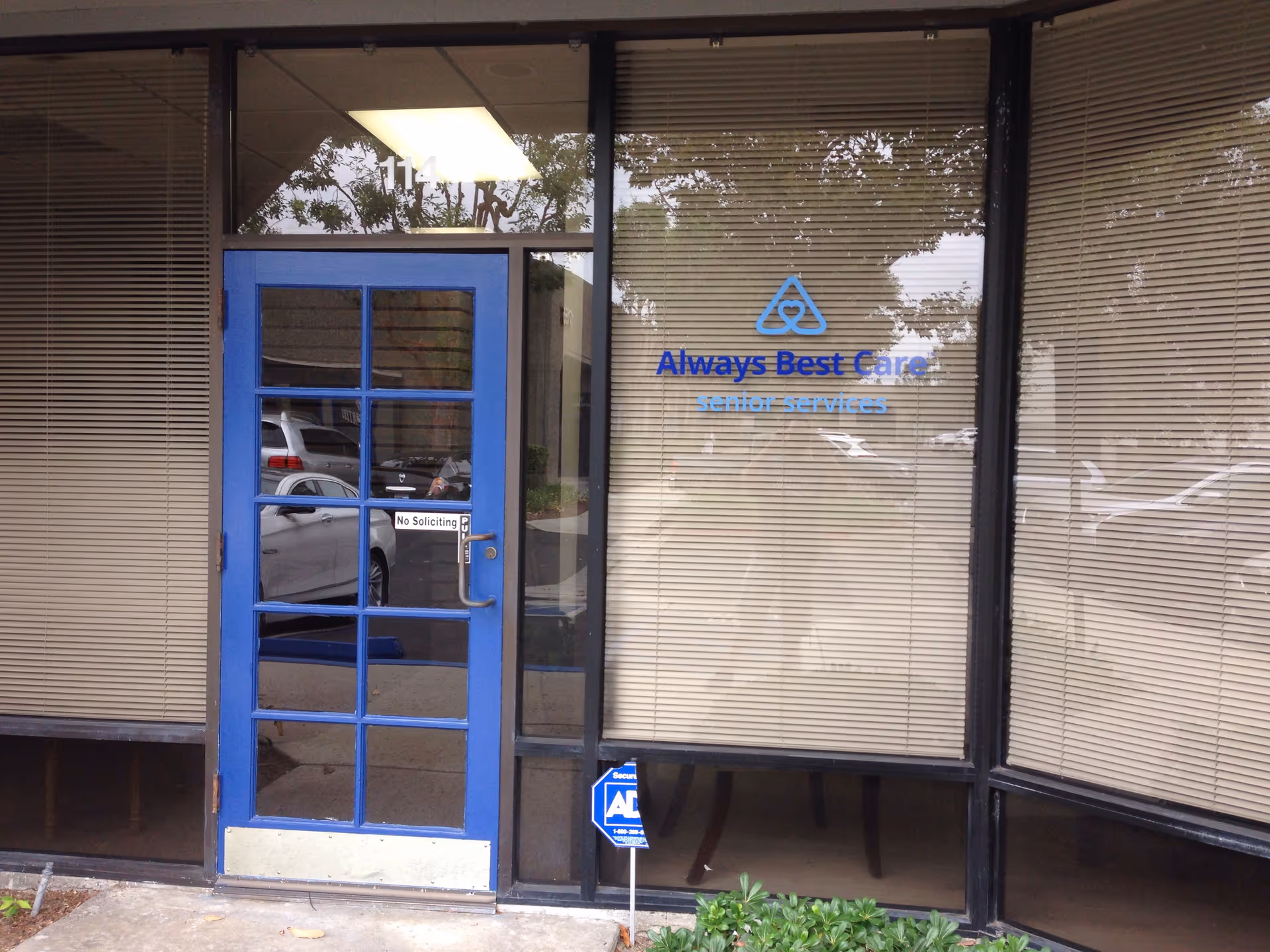 Blue-framed glass door storefront with beige blinds and Always Best Care sign.