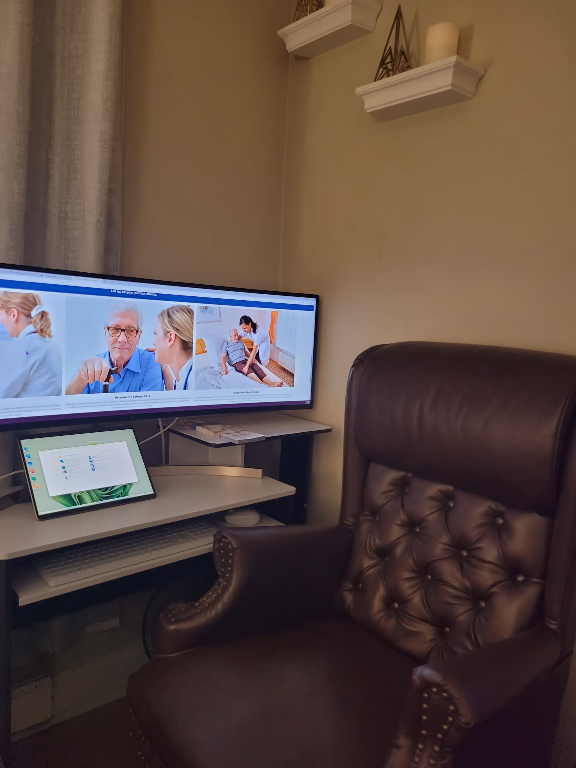 Brown leather chair beside a desk and large monitor displaying healthcare site.