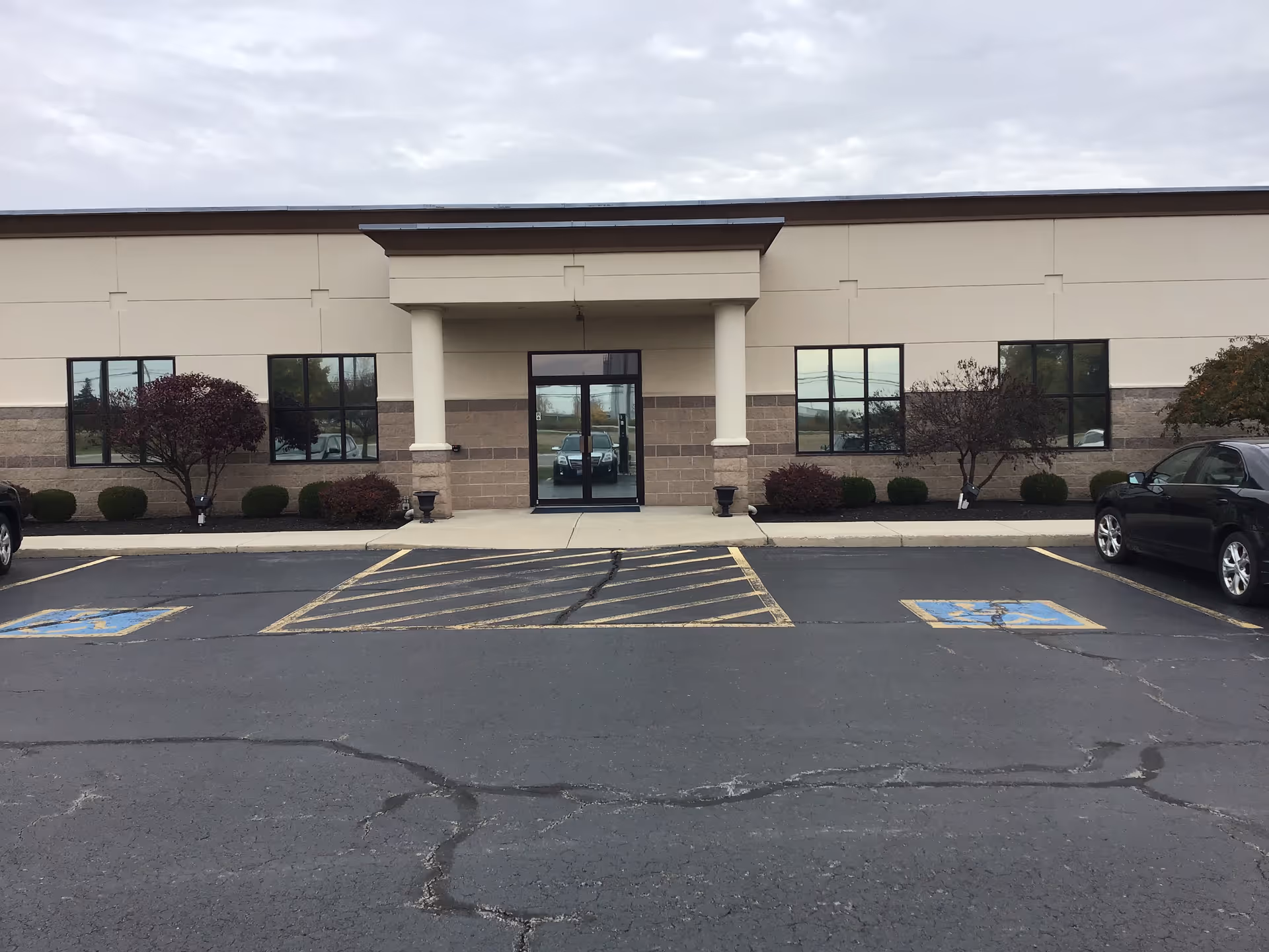 Front exterior of a beige Comprehensive Health Network building with a glass entrance.