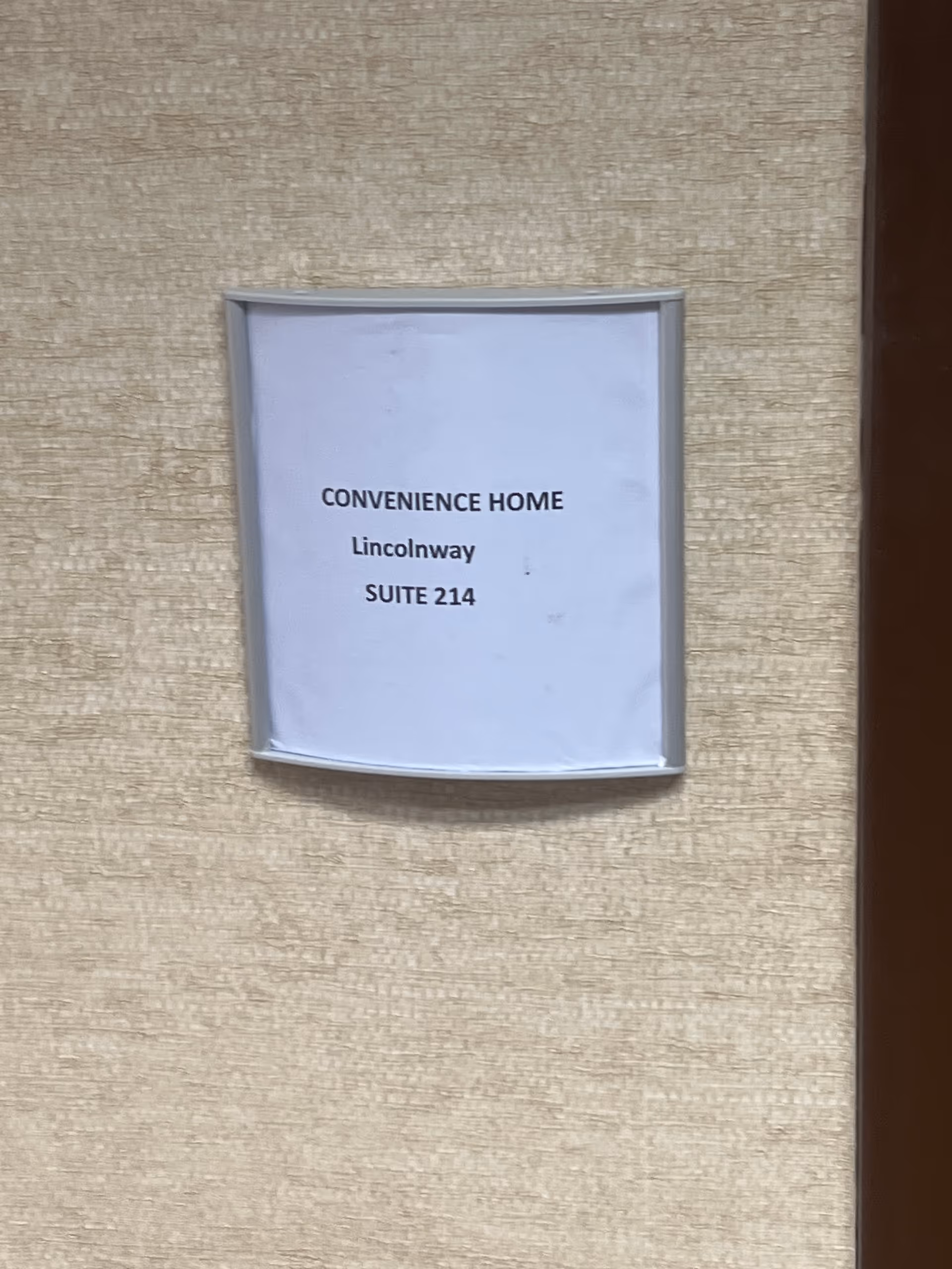 A sign on a beige textured wall reads Convenience Home Lincolnway Suite 214