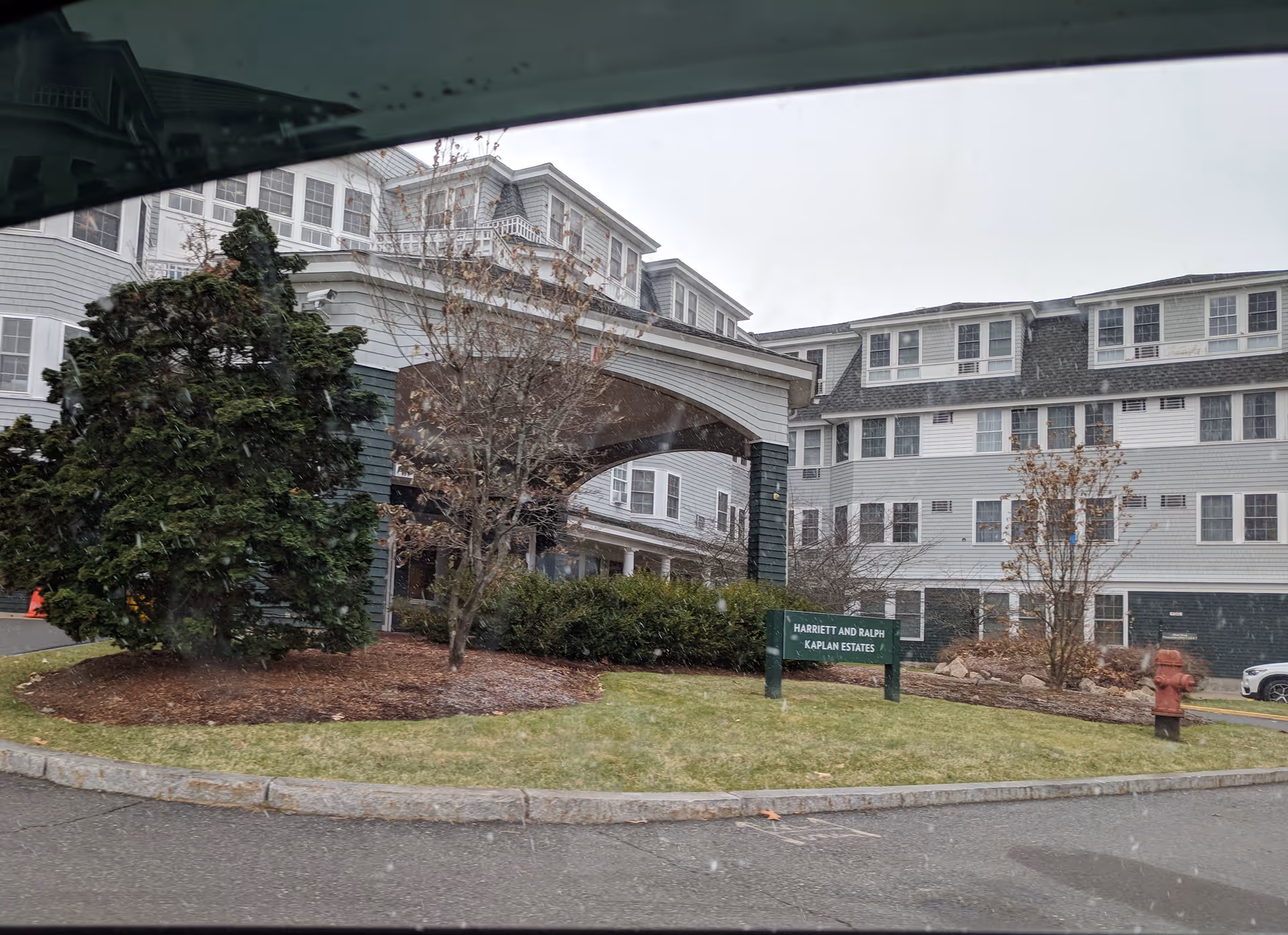 Exterior view of Legacy at Harriett and Ralph Kaplan Estates, showing entrance canopy and landscaping.