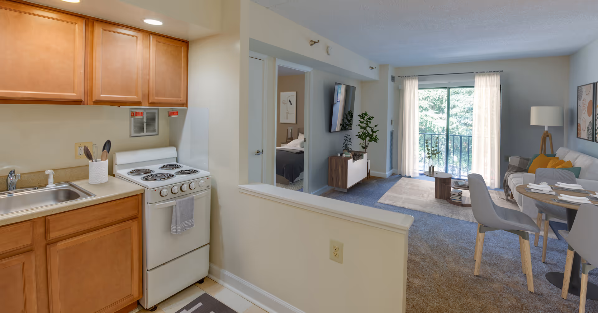 Open-concept kitchen adjacent to living area with balcony view.