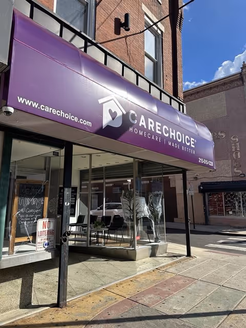 Purple CareChoice Homecare storefront awning over glass doors on a city street.
