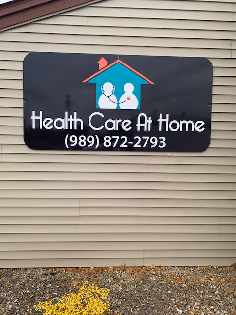 Exterior building sign reads Health Care At Home with logo and phone number.