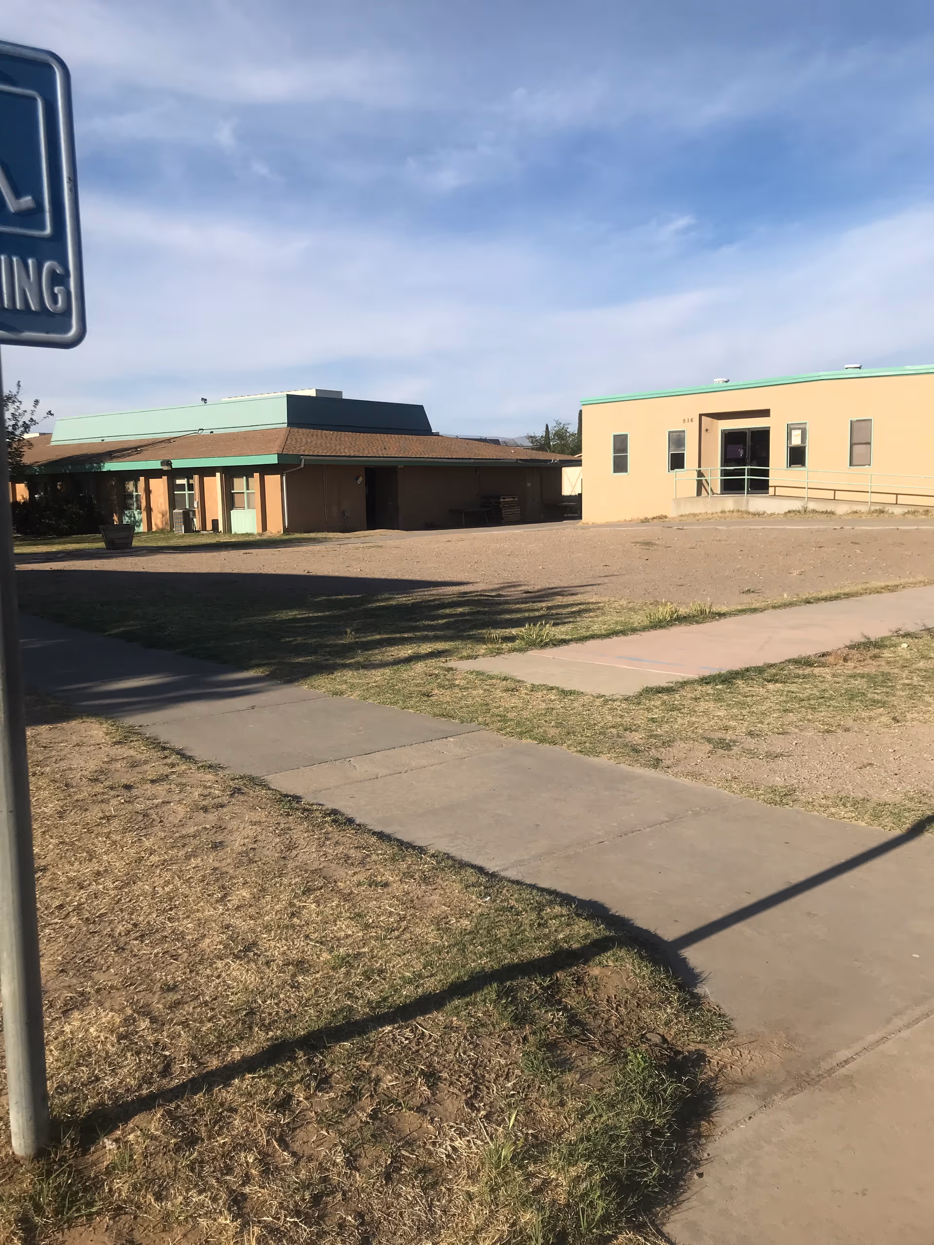 Exterior view of El Paso State Supported Living Center with beige buildings and a sidewalk.