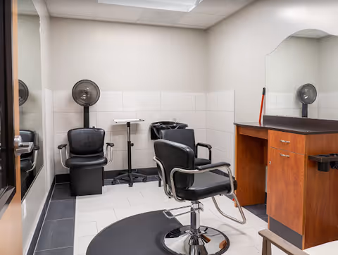 Interior view of a hair salon with styling chairs, mirrors, and a sink.