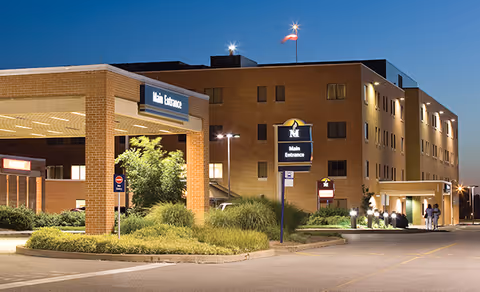 Exterior view of Protestant Memorial Med Center entrance with signs and parked drive-up area.