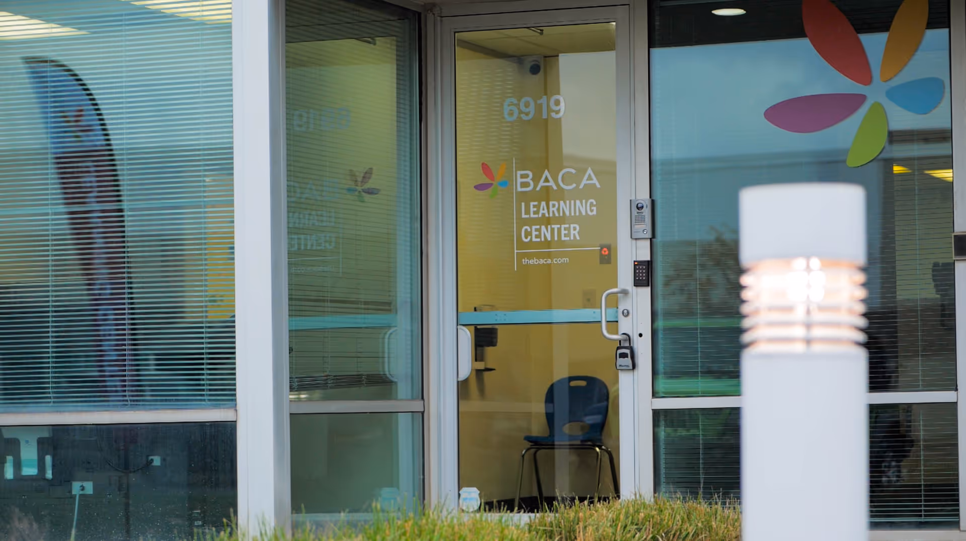 Front entrance of BACA Learning Center with glass doors and blinds.
