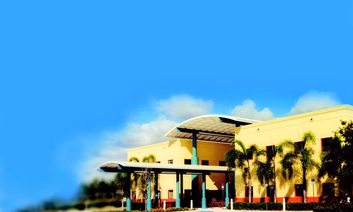 Exterior view of Nicklaus Children's Dan Marino Outpatient Center with palm trees and blue sky.