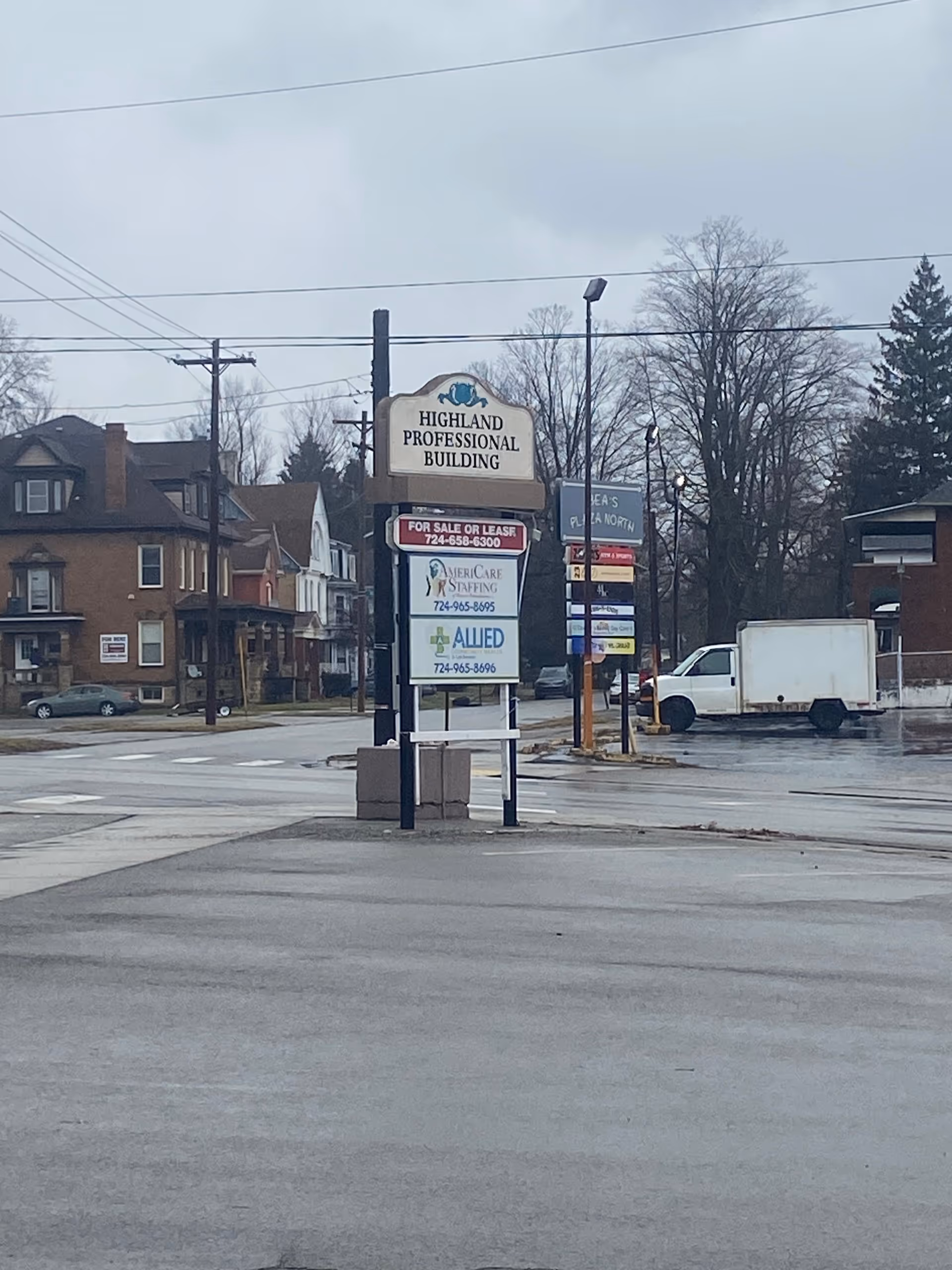 Street intersection with Highland Professional Building sign and AmeriCare Staffing banners.