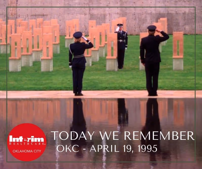 Outdoor memorial with saluting uniformed personnel and a reflecting pool.