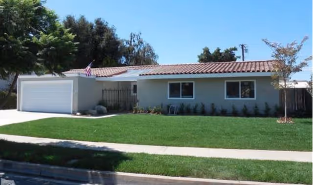 Front exterior of a single story facility with a garage and a green lawn.